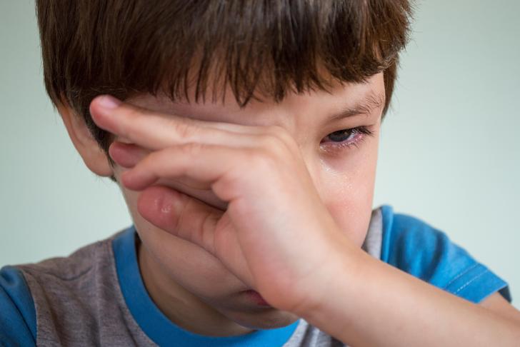 boy rubbing his eyes