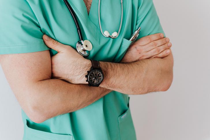 doctor in blue scrubs with arms crossed