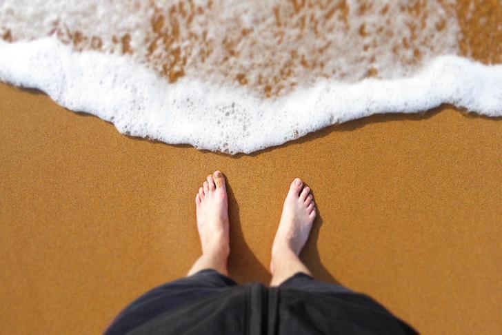 feet in the sand at the beach