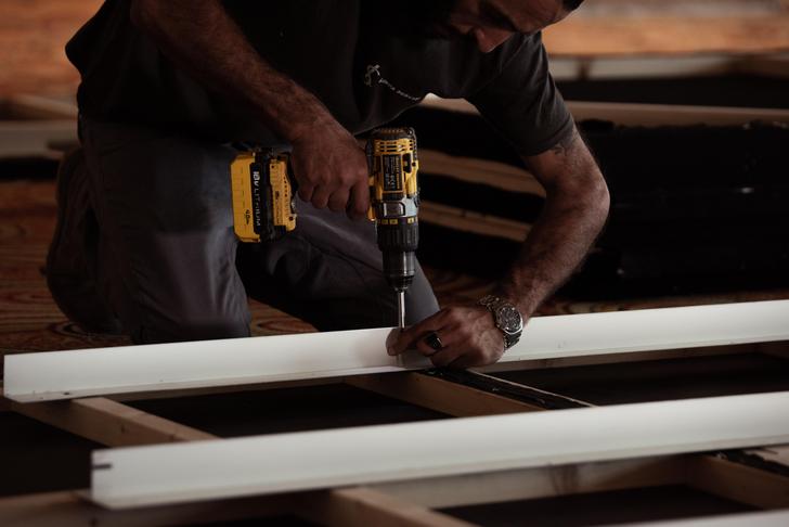 man drilling wood