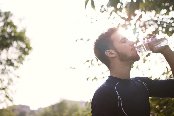 man drinking water in nature