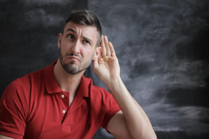 man holding hand near ear