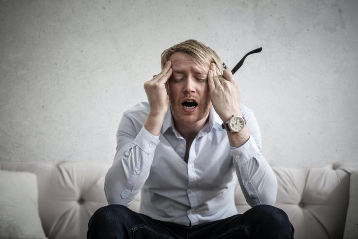 man holding head in pain