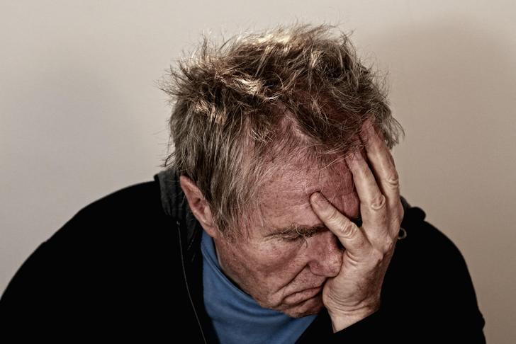 man holding his face in his hand