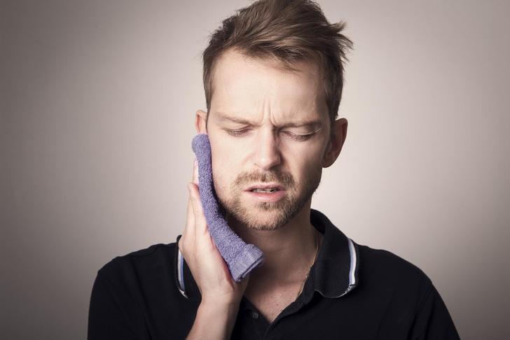 man holding jaw in pain