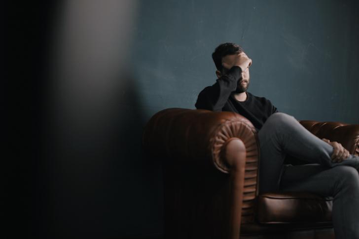 man sitting with hand on his head