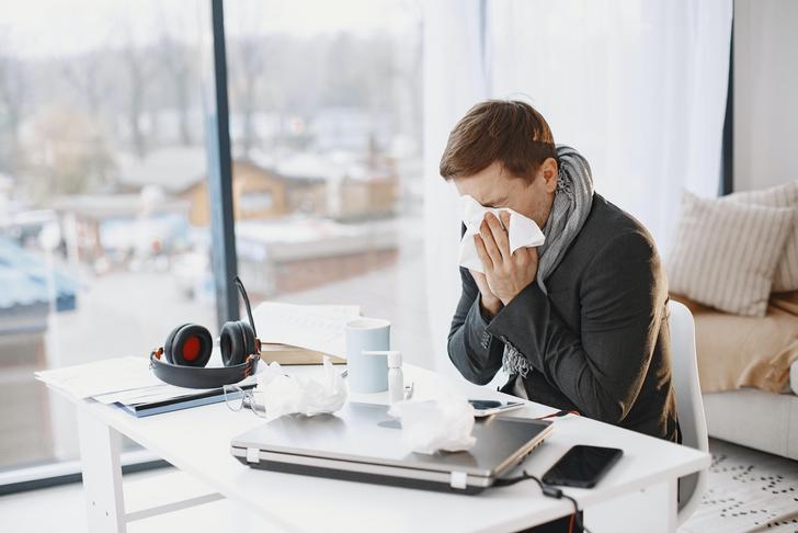 man sneezing into tissue