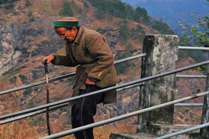 man walking down stairs with stooped posture