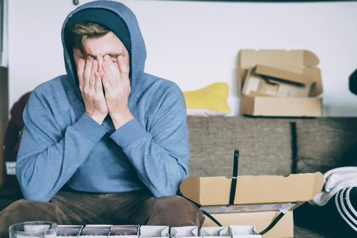 man with hands covering his face