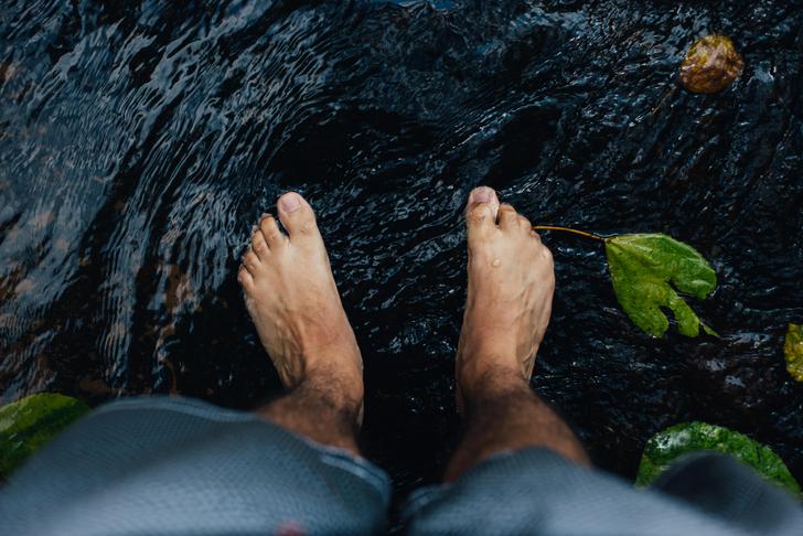 person's feet in water