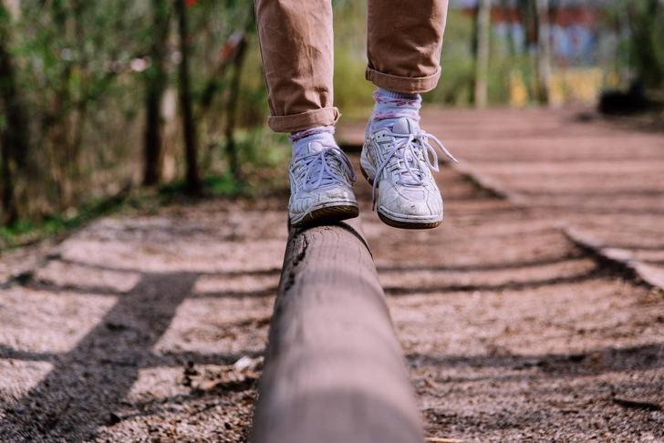 person balancing on tree trunk