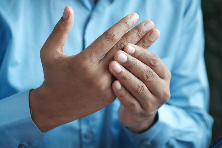 person holding one hand with their other hand