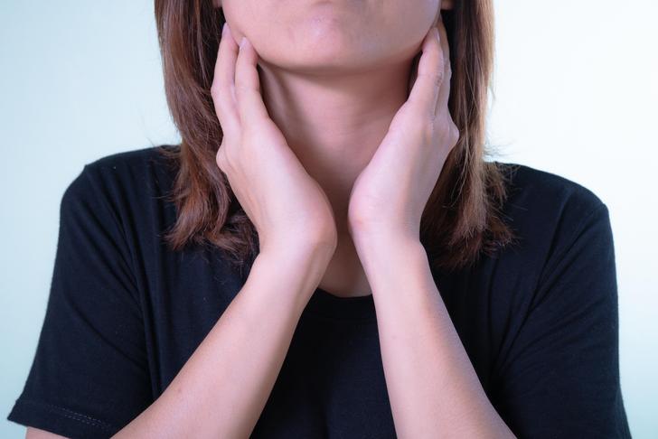 person lightly touching side of their neck