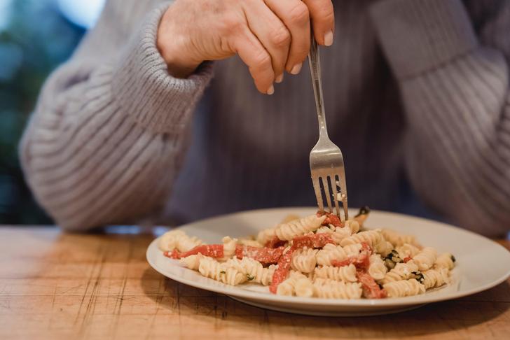 person playing with their plate of food