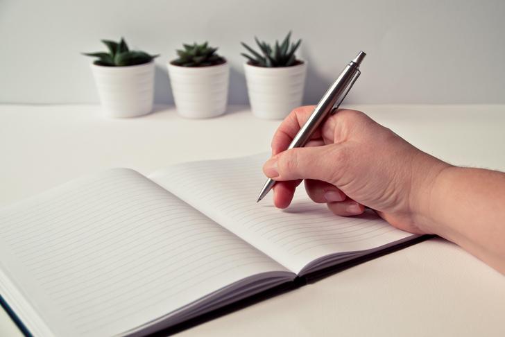 person writing in notebook