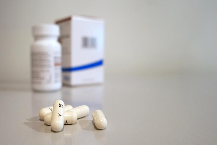 pills on a table with bottle and box in the background