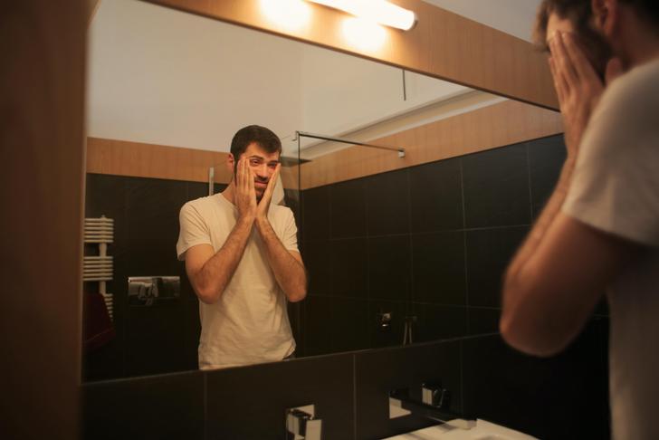 sick man looking in the mirror at himself