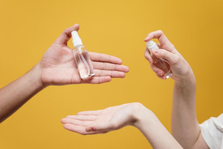 two people holding spray bottles