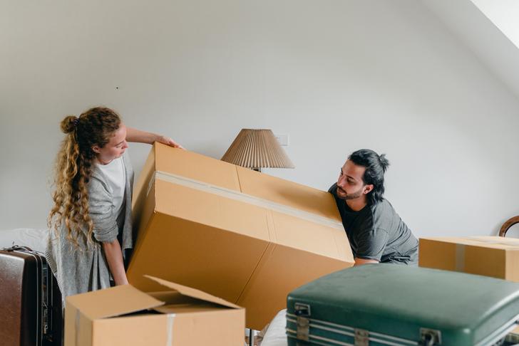 two people lifting a heavy box