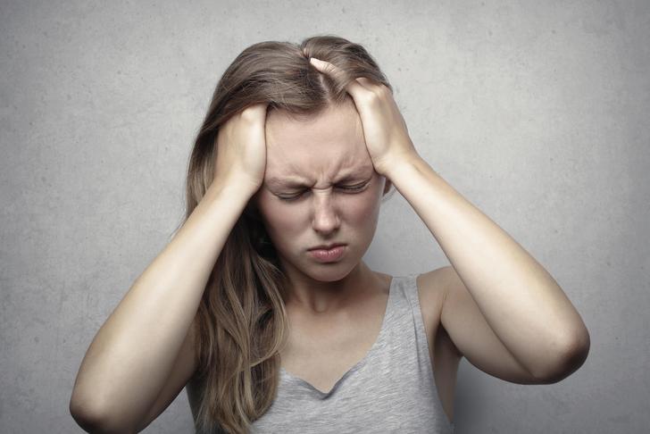 woman holding head in pain