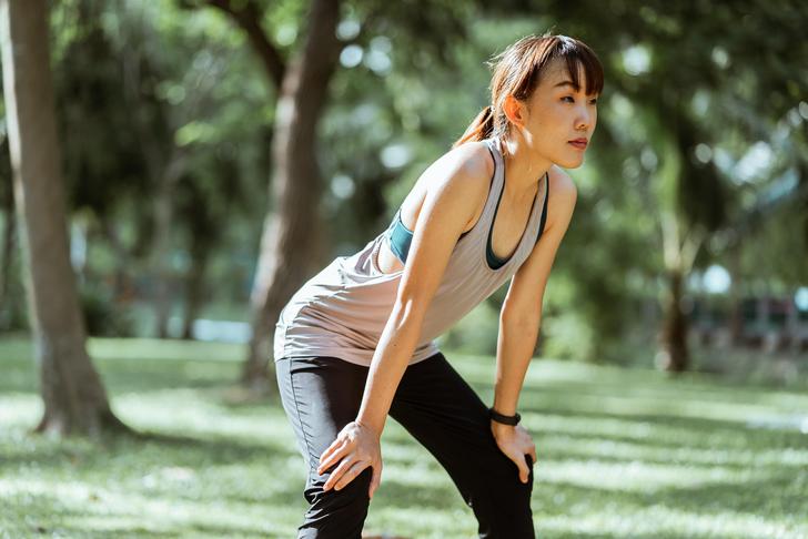 woman resting hands on knees after physical activity