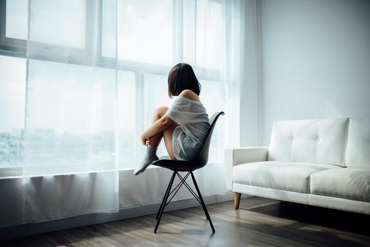 woman sitting in chair looking out window