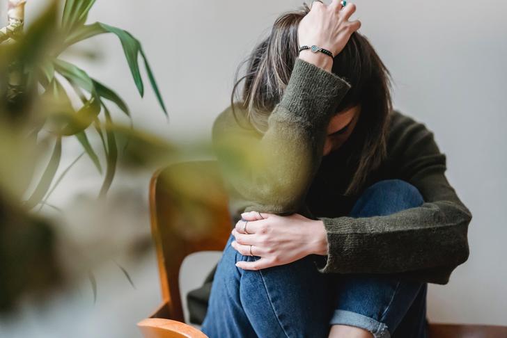 woman sitting in chair with head in hands