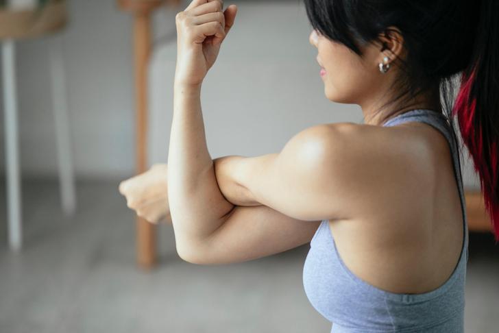 woman stretching arm across body